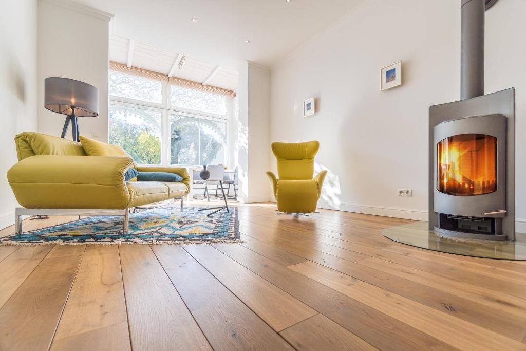 a living room with a yellow couch and a fireplace at Appartement Baltic Pearl in Ostseebad Sellin