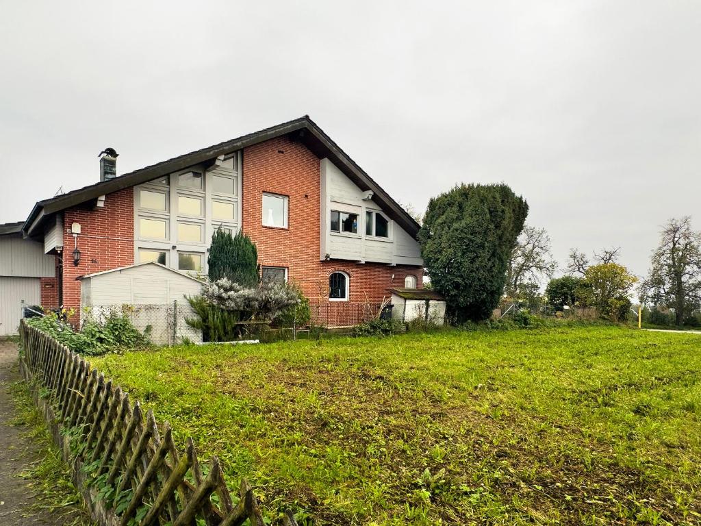 a house with a fence in front of a field at Apfelstübchen in Friedrichshafen