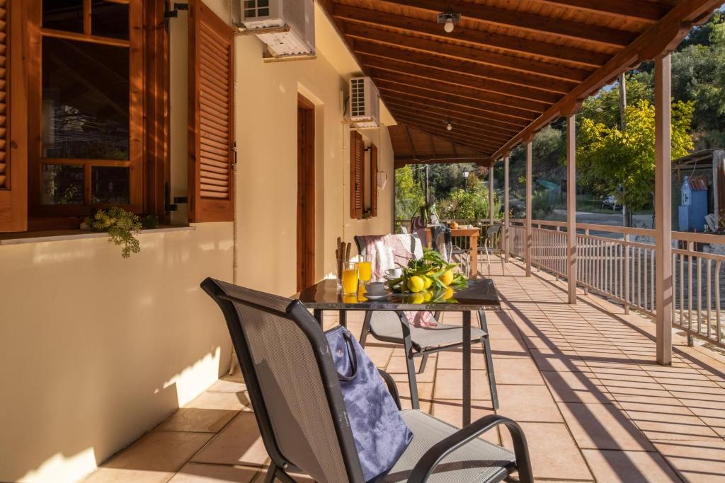 a patio with a table and chairs on a porch at Krinos apartment 1 in Kharadhiátika