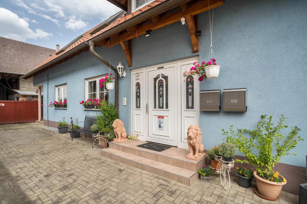 a blue house with two statues in front of it at Ferienwohnung Schläfer in Kappel-Grafenhausen