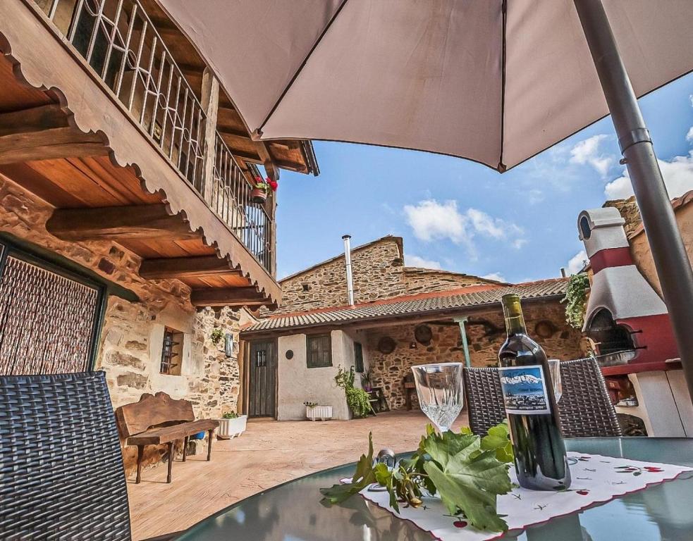 a patio with a table with a bottle of wine on it at Jumaca in Valdespino de Somoza