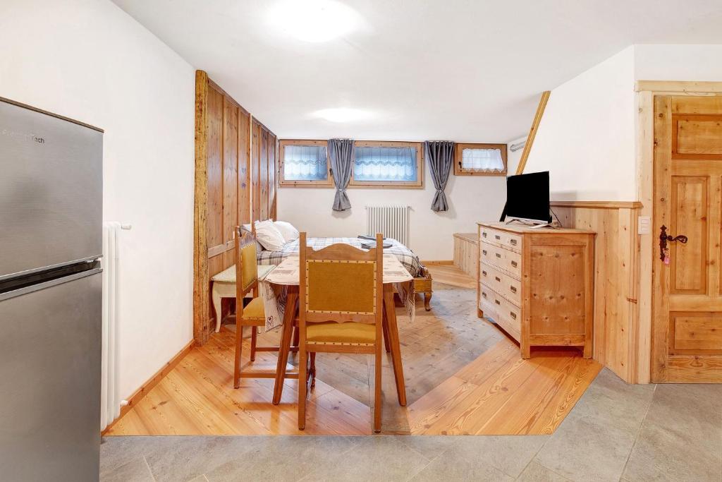 a kitchen and dining room with a table and a refrigerator at Premesan 4 in Bormio