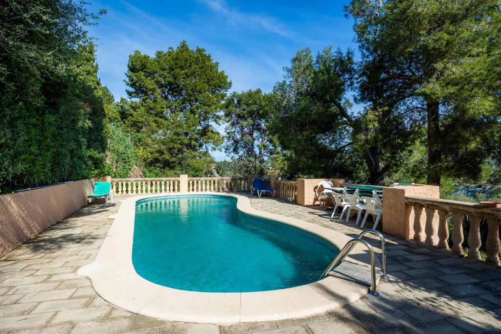 a pool with a table and chairs next to a fence at Montemar 33 in Port de Soller