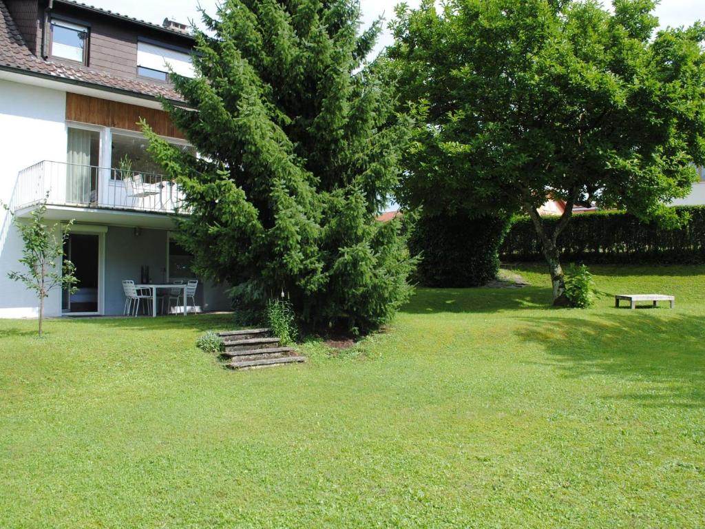 a house with a tree and stairs in the yard at Ferienhaus Joos in Uhldingen-Mühlhofen