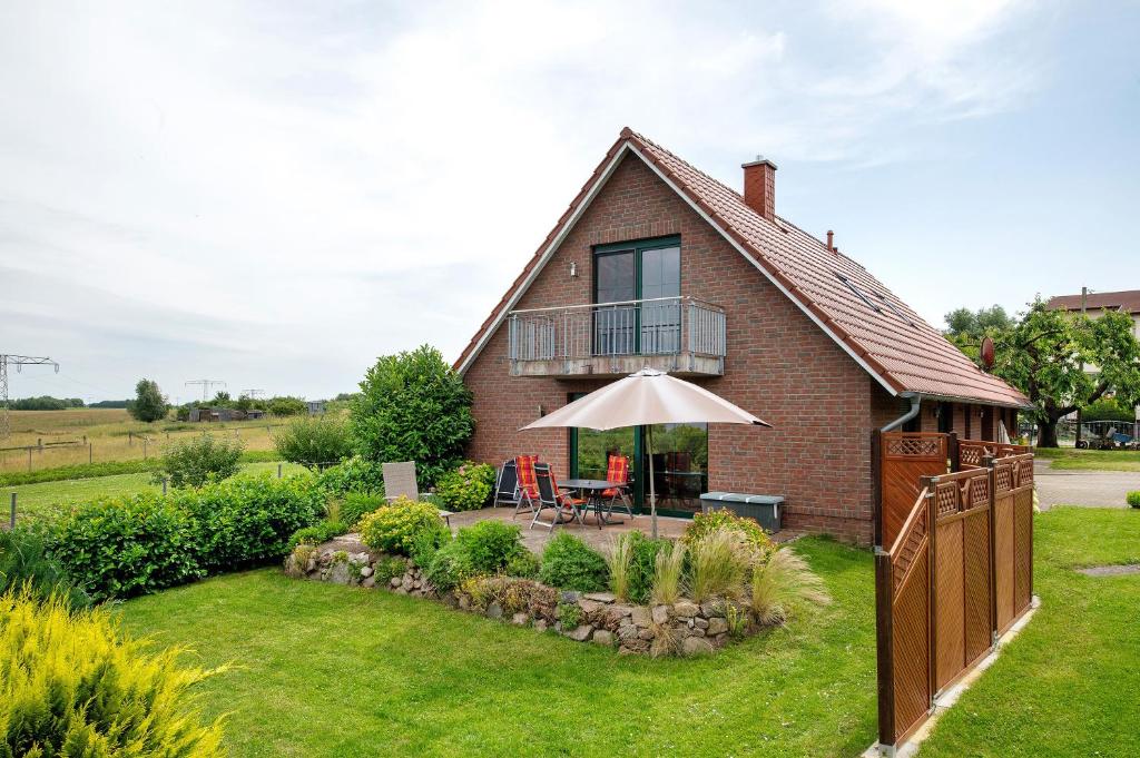 a house with a patio and an umbrella at Großes Ferienhaus mit Seeblick in Leezen