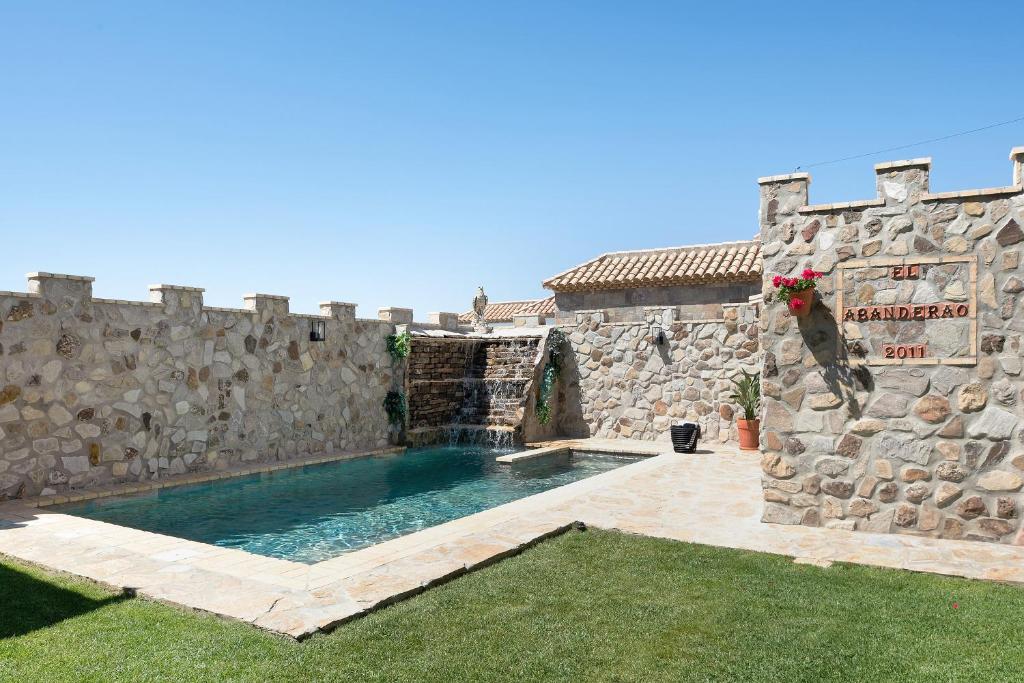 a stone building with a swimming pool in a yard at Loft Abanderao Piscina y Jacuzzi in Conil de la Frontera