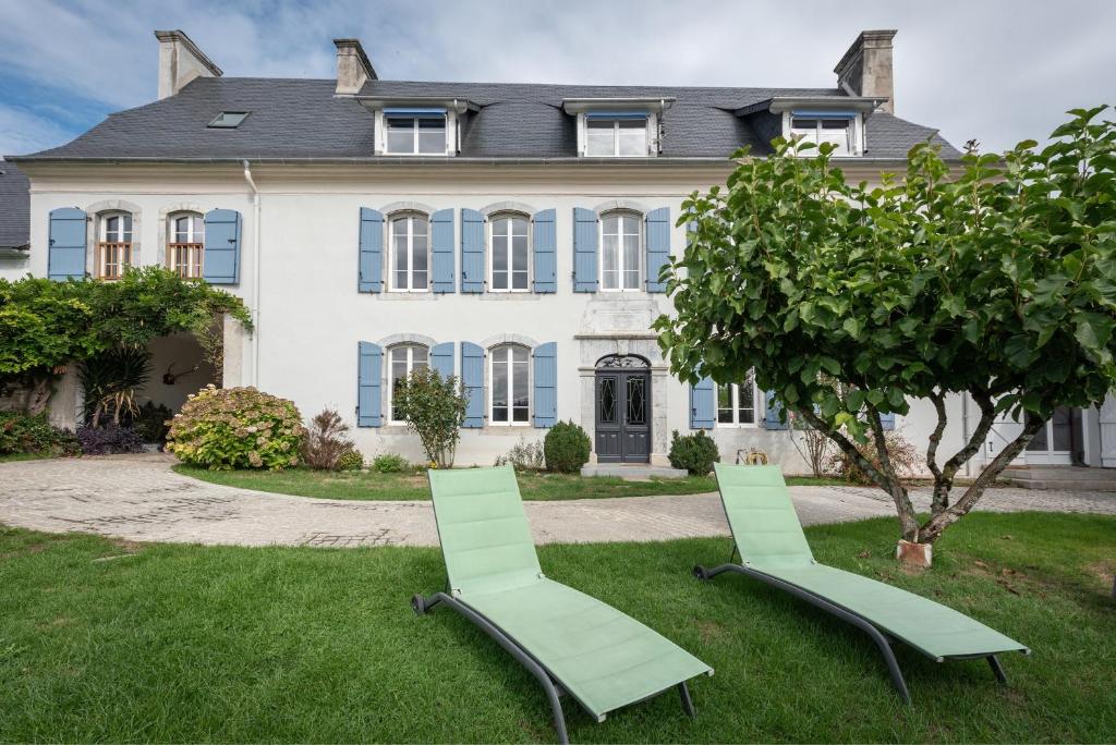 two lawn chairs in front of a house at Chambres D'hôtes Maison Galouÿe in Montgaillard