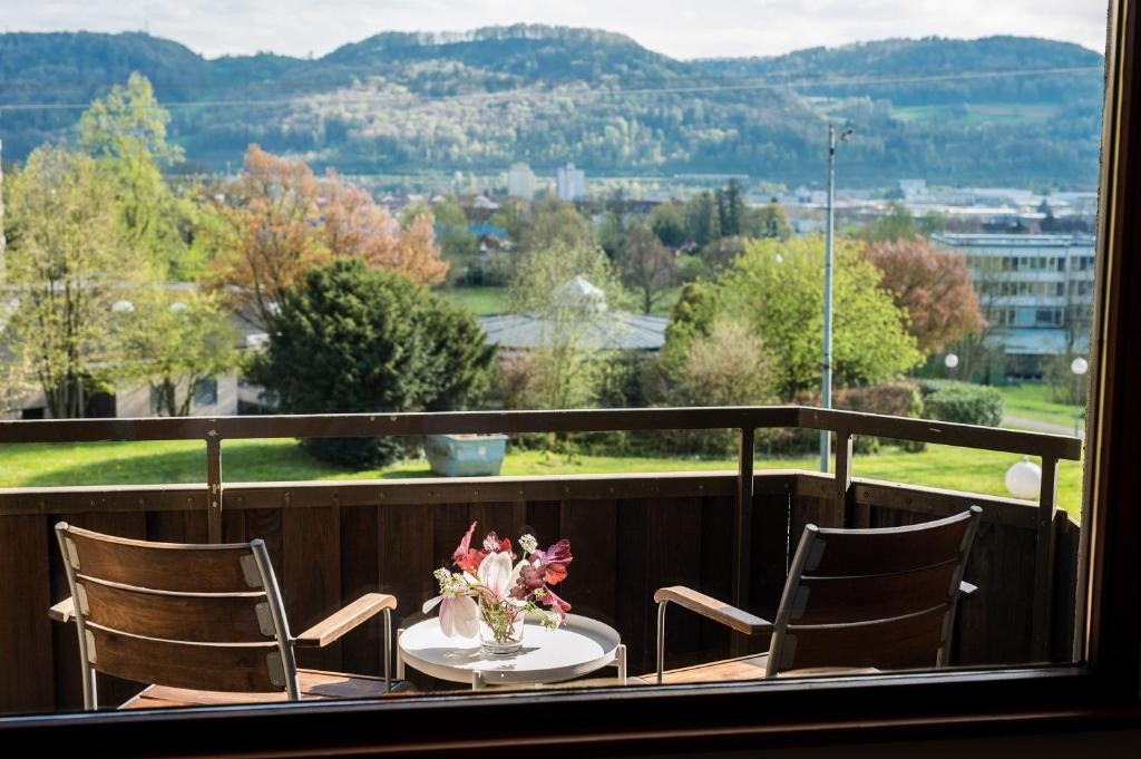 a table with chairs and a vase of flowers on a balcony at Fewo Schneckenhalde App 18 in Bad Säckingen