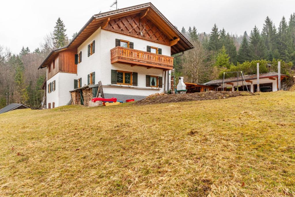 a house on top of a grassy hill at Ferienwohnung Kraus Eibsee in Grainau