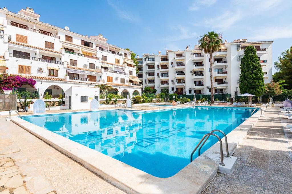 a large swimming pool with buildings in the background at Los Arcos in Alcossebre
