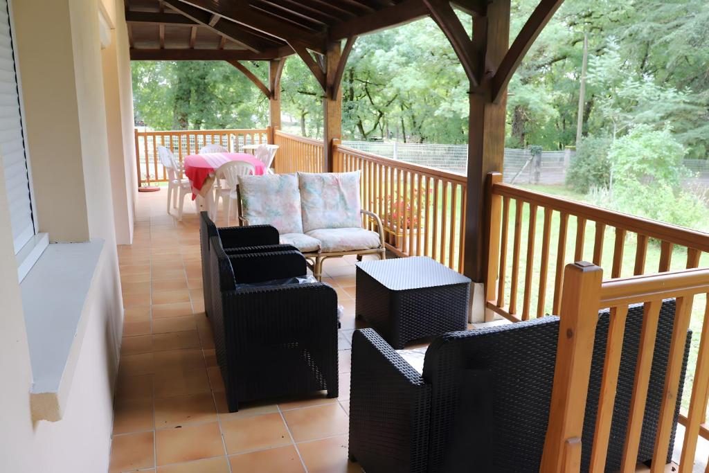 a porch with chairs and a table on a deck at Gite Chez Jeanne in Pern