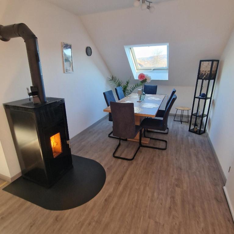 a living room with a wood stove and a table at Fränkisch wohnen bei Mela in Litzendorf