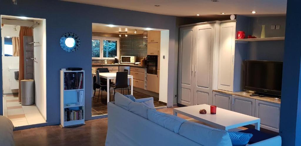 a living room with a couch and a table and a kitchen at Le Coq De Champagne in Dormans