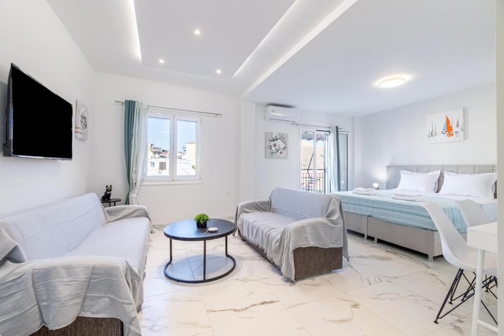 a white living room with a bed and a couch at Corfu Haven in Ágios Rókkos