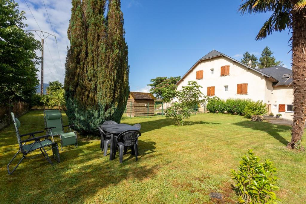 a yard with a table and chairs and a tree at T3 Aramits Pyrénées Béarnaises in Aramits