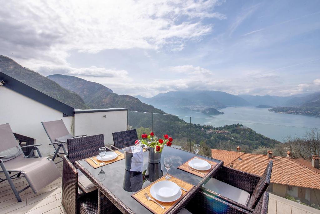 a table on a balcony with a view of a lake at Relax and Happiness private Jacuzzi in Perledo