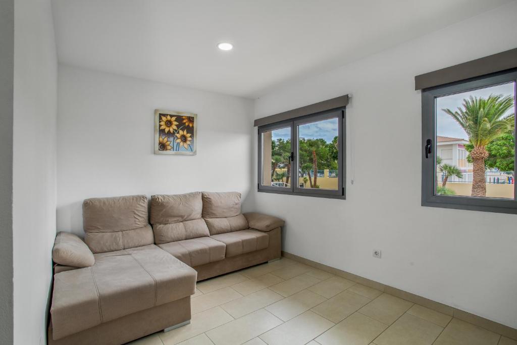 a living room with a couch and two windows at Edificio Bentejui 1 in Las Palmas de Gran Canaria