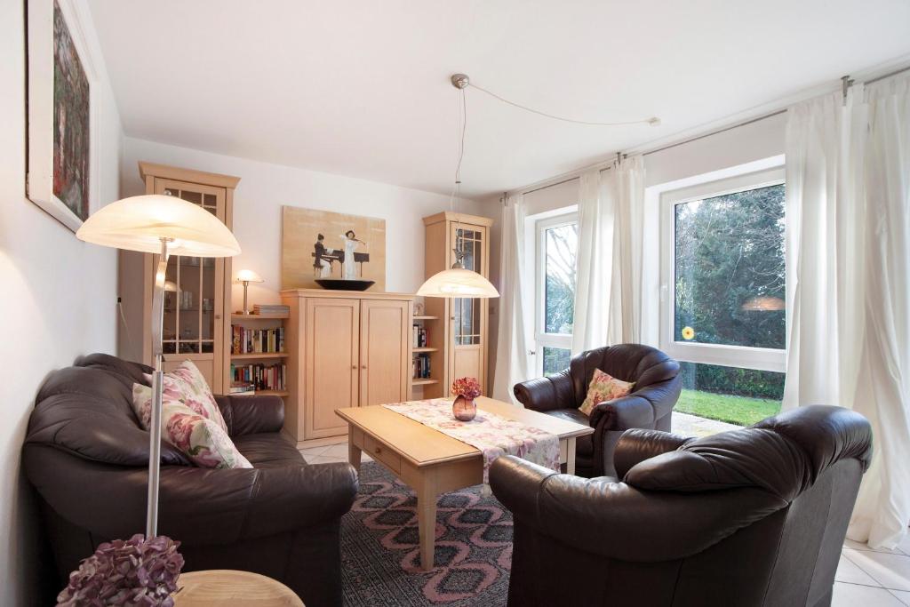 a living room with leather chairs and a table at Ferienwohnung Schoeneberg in Vogt