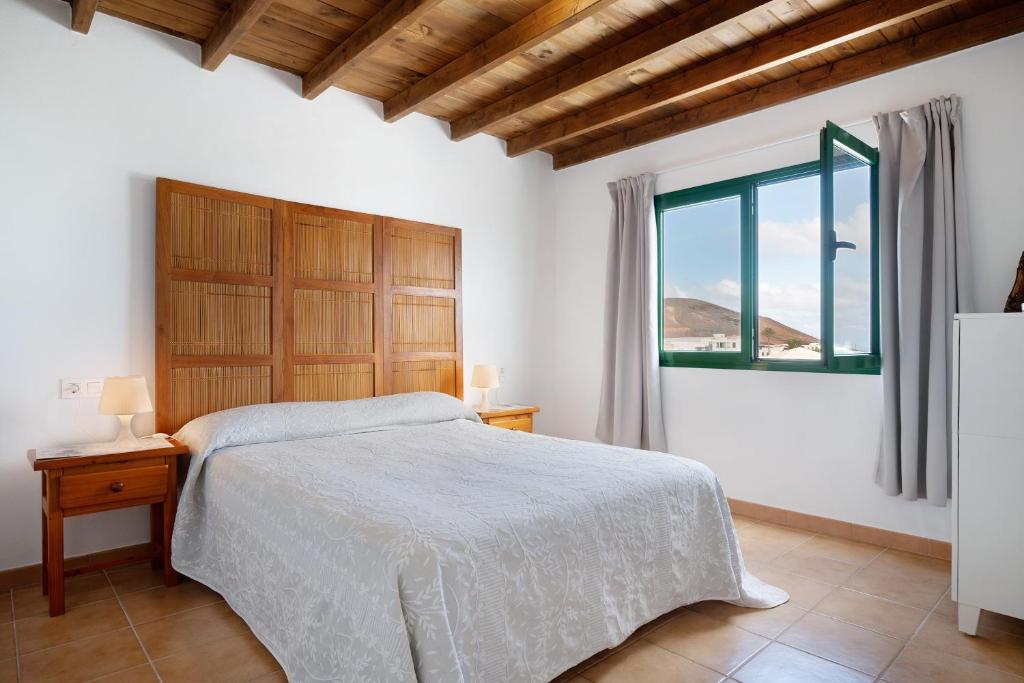 a white bedroom with a bed and a window at San Roque 2 in Tinajo