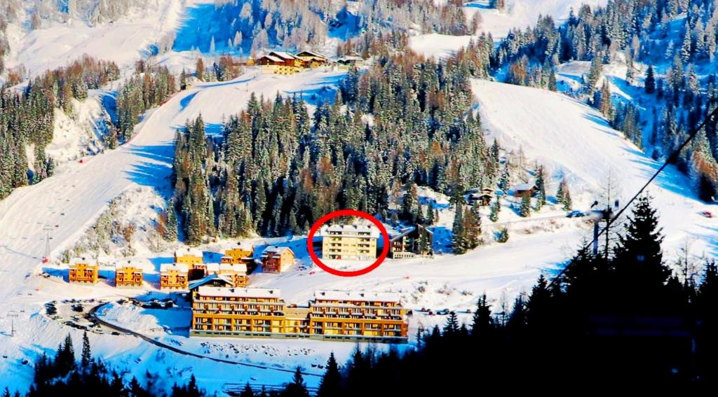 a building in the snow next to a mountain at Apartments Bergblick in Sonnenalpe Nassfeld