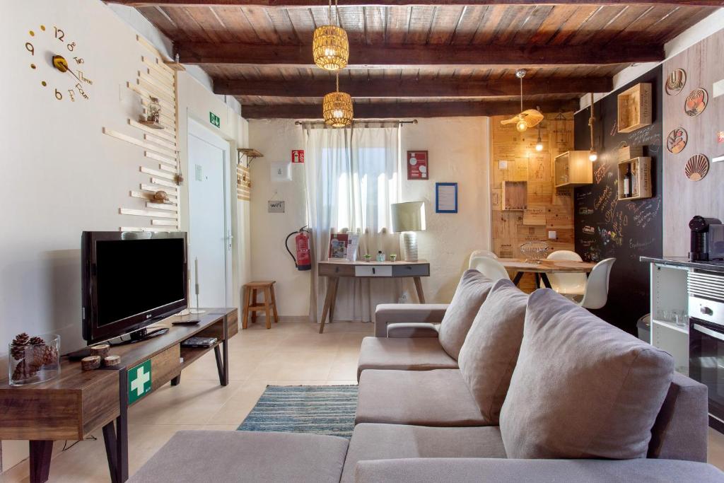 ein Wohnzimmer mit Sofa und Fernseher in der Unterkunft Recanto Do Pinhal E Mar in Carriço