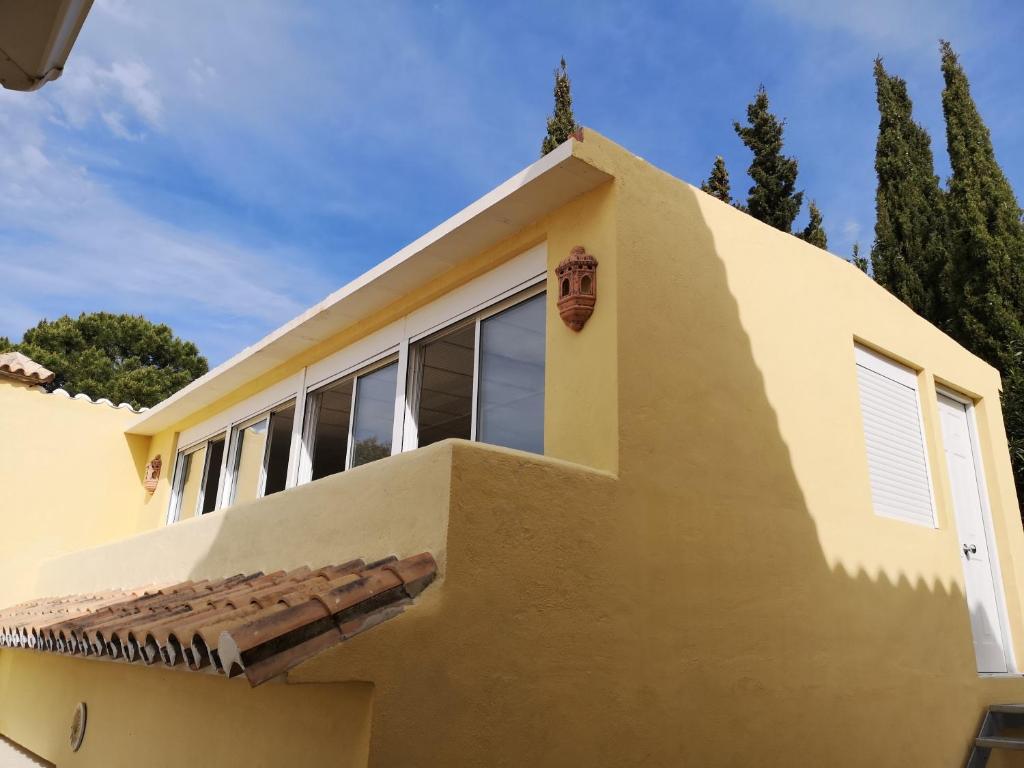 a yellow house with windows and a roof at Roca Penthouse in Estepona