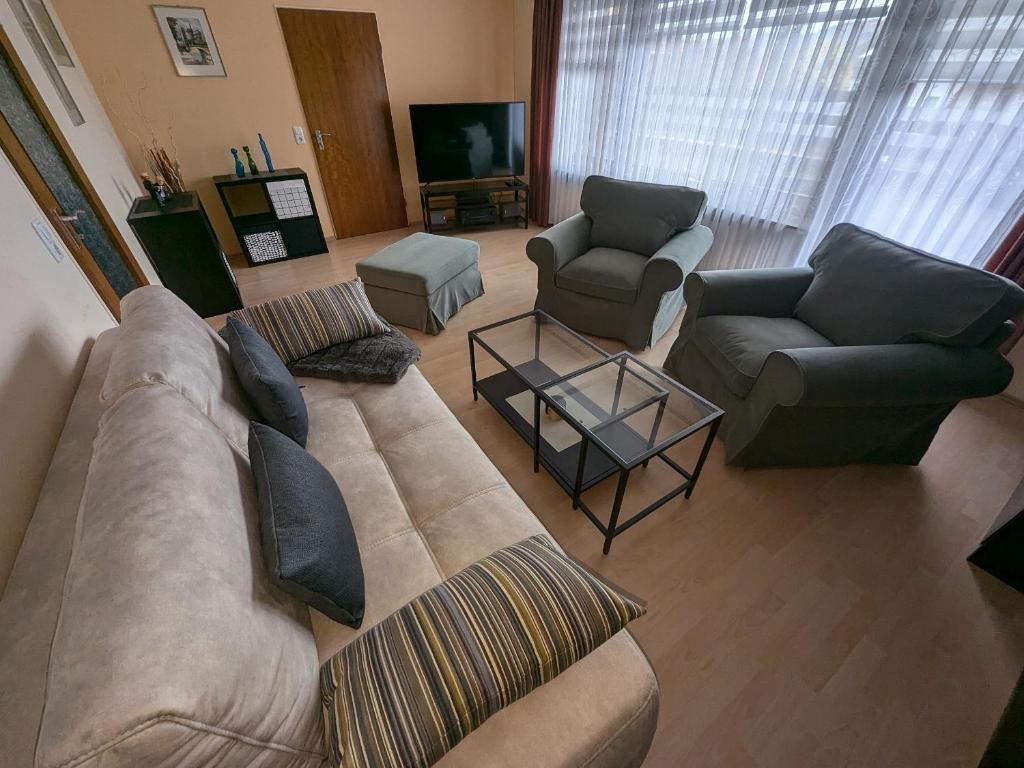 a living room with a couch and two chairs at Ferienwohnung Buedinger Weg in Gründau