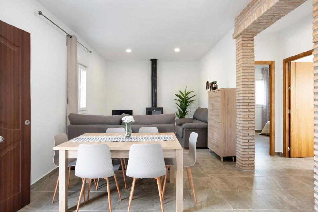 a dining room with a table and white chairs at Villa Montenmedio - Paula in El Soto
