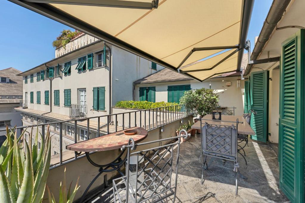 a balcony with a wooden table and a table at Attico Palazzo Giustiniani in Genoa