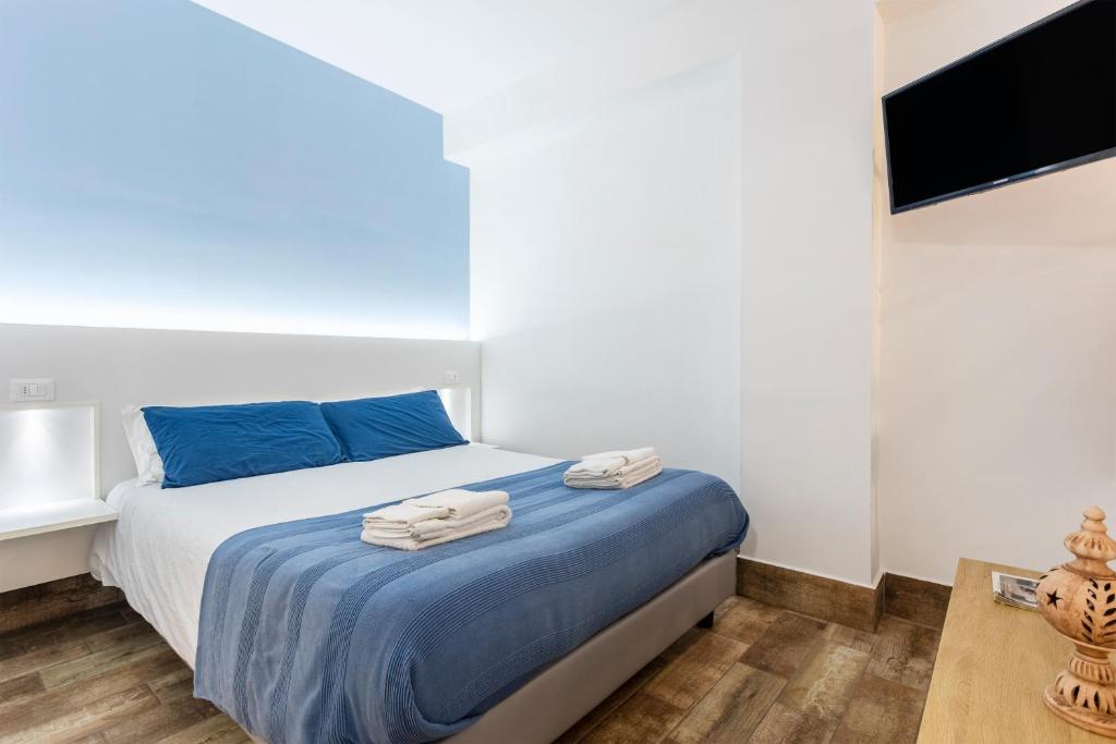 a bedroom with a bed with blue sheets and a tv at Casavacanzefranca - 15 in Terrasini