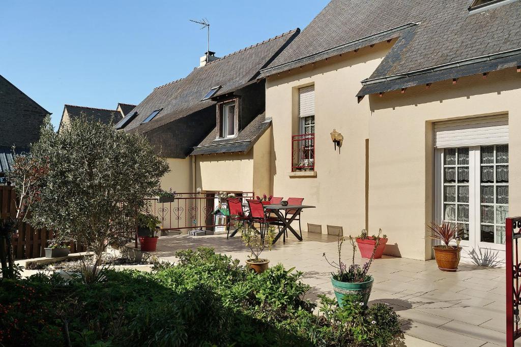 a house with a patio with a table and chairs at Chambre d'hote Reine in Cancale