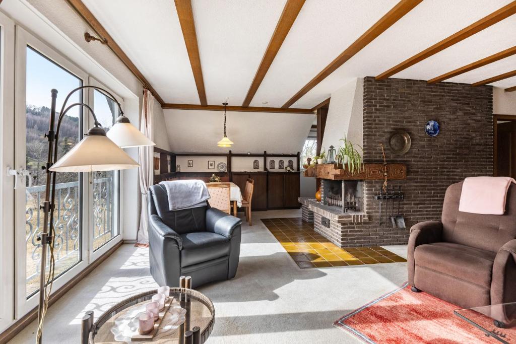 a living room with two chairs and a fireplace at Ferienwohnung Grothoff in Olsberg