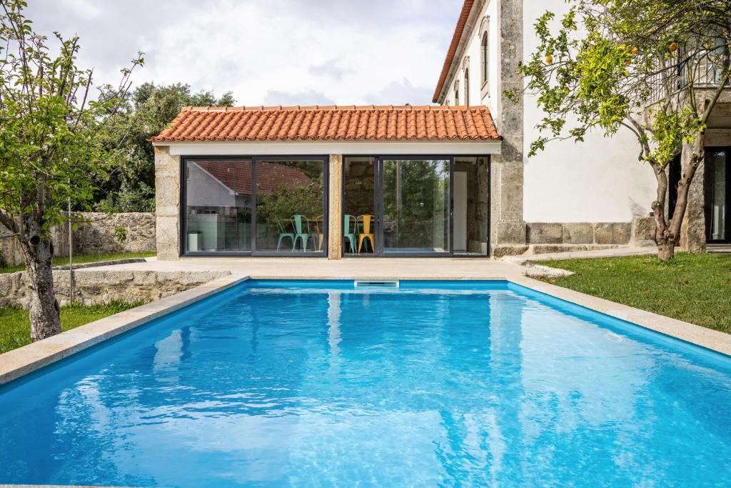 a swimming pool in front of a house at Casa do Mestre Studio e Suíte Extra in Vila de Punhe