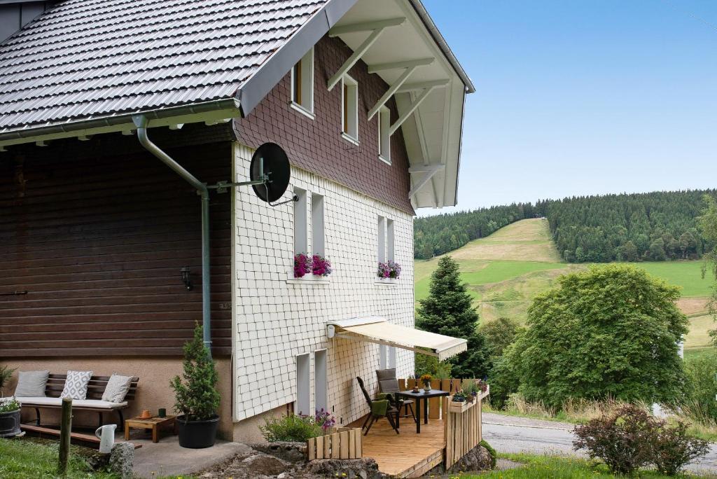 a house with a patio with a table and chairs at Haus Bergruh Kuckucksnest in Todtnauberg