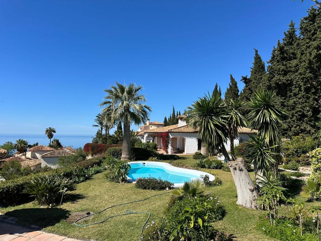 a house with a swimming pool and palm trees at Villa Tropical Dream in Salobreña