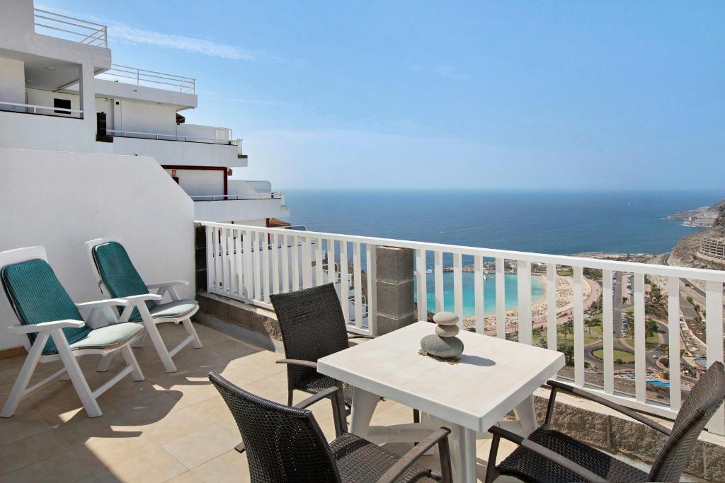 a balcony with a table and chairs and the ocean at Balcón de Amadores - Beach view in Puerto Rico de Gran Canaria