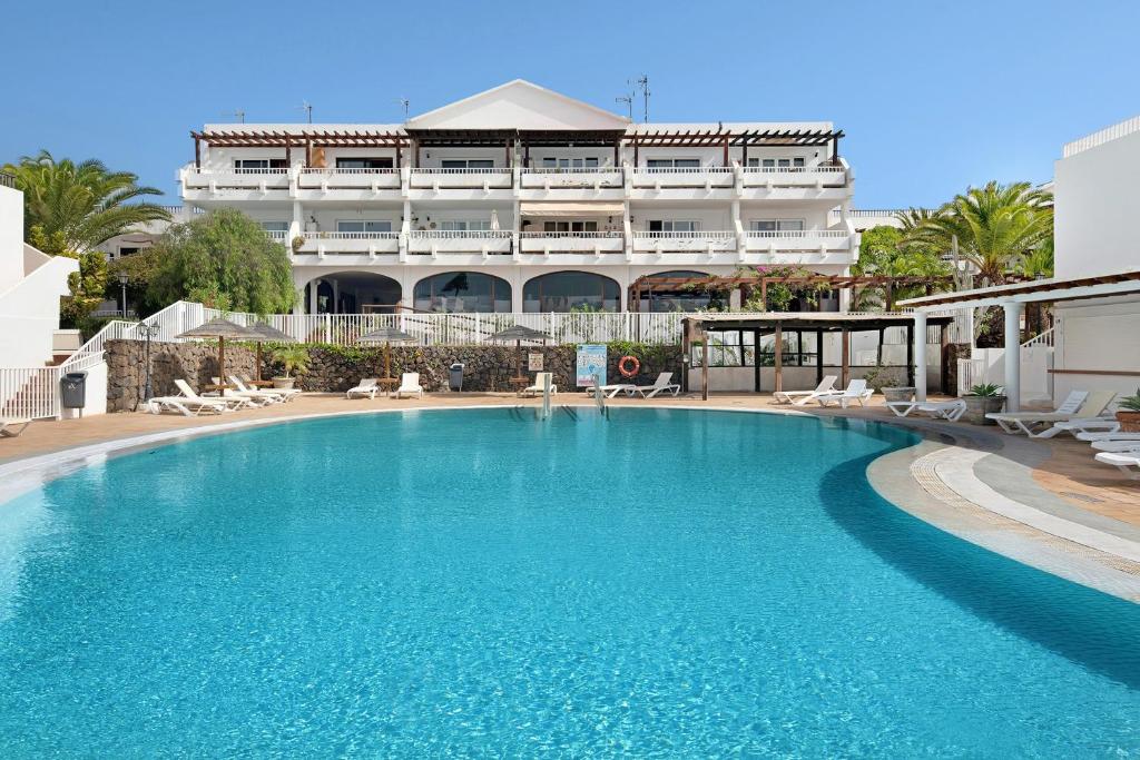 a large swimming pool in front of a hotel at Casa Paloma in Costa Teguise