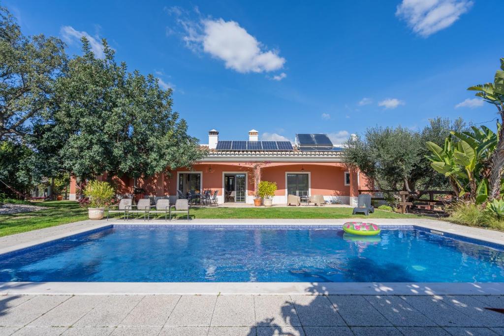 a swimming pool in front of a house at Quinta Dos 4 Ventos in Silves