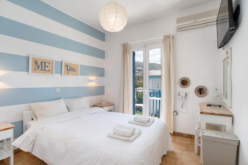 a bedroom with a white bed and a window at Livadia Seaside Studios 13 in Parikia