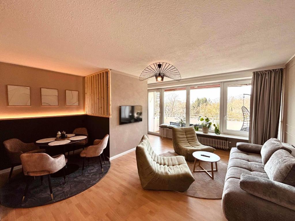 a living room with a couch and a table and chairs at Apartment Kokorey in Halstenbek