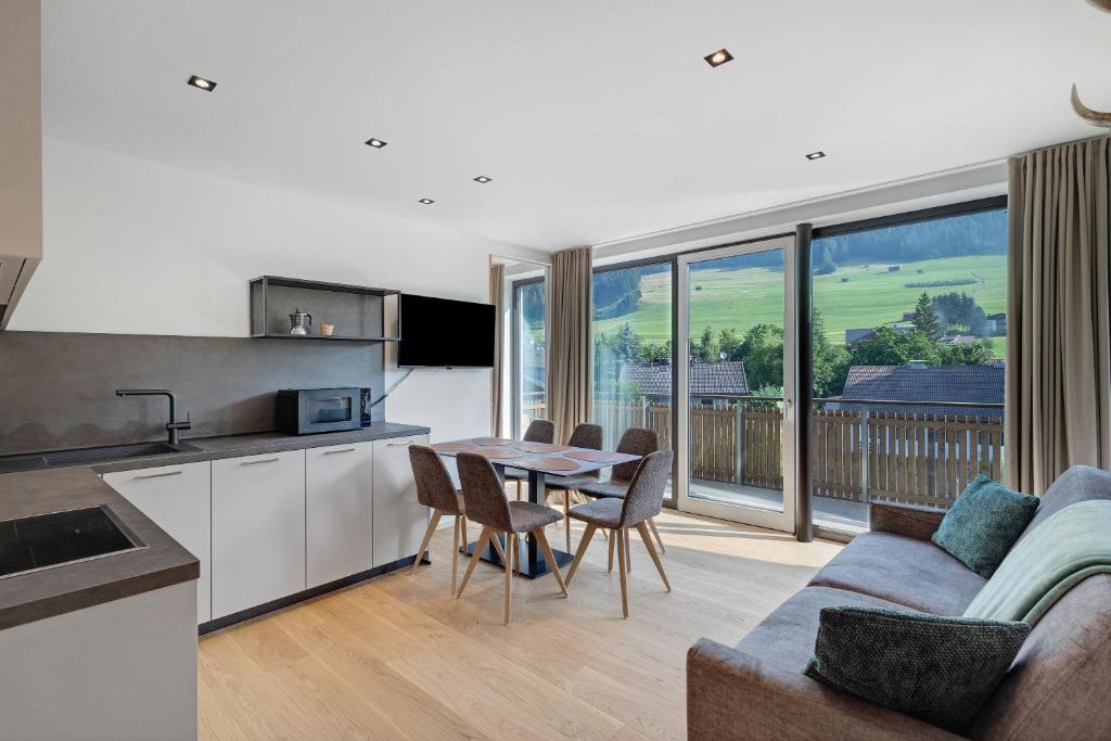a kitchen and living room with a table and a couch at Premium App Hofer Silena in Villabassa