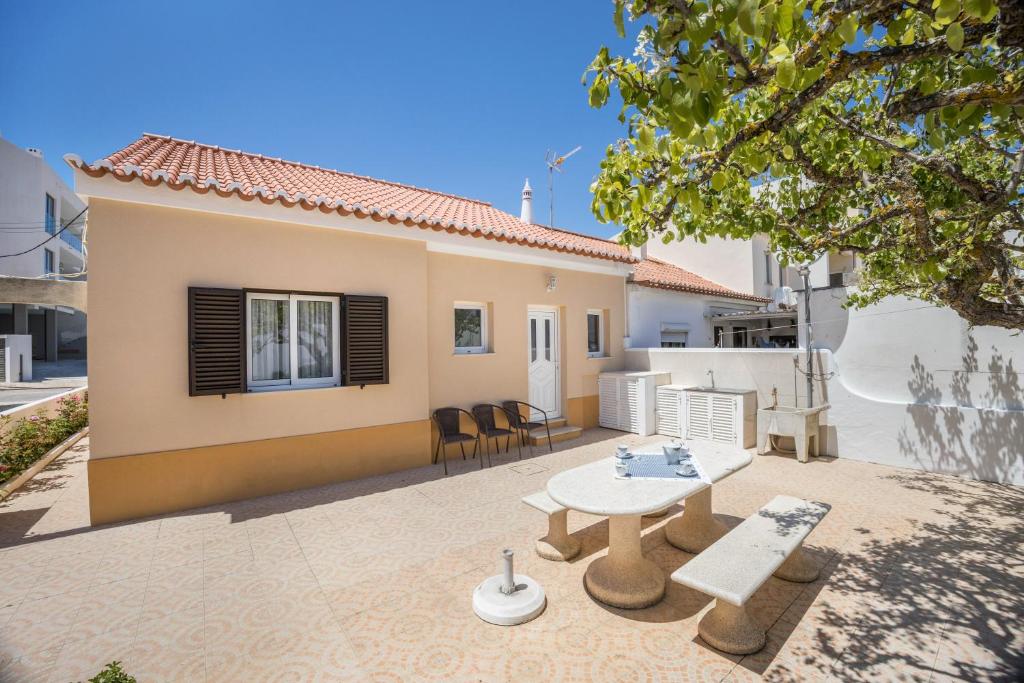 a patio with a table and chairs in front of a house at Casa Fernandes in Burgau