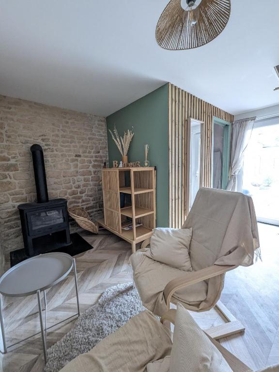 a living room with a couch and a chair at Jo And Manu's Barn in Falaise