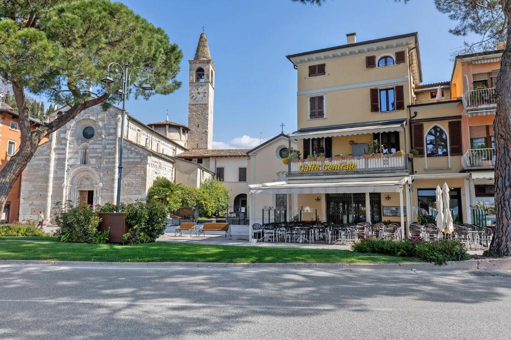 a building with a clock tower and a church at Casabb in Toscolano Maderno