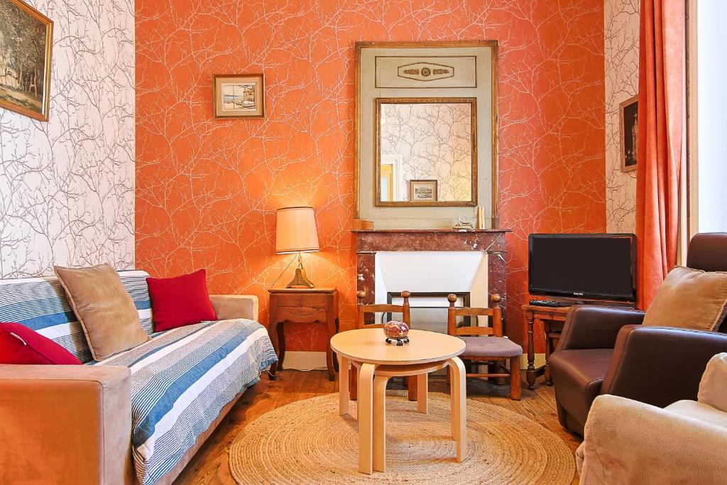 a living room with a couch and a table at Villa Rosella in Les Sables-d'Olonne