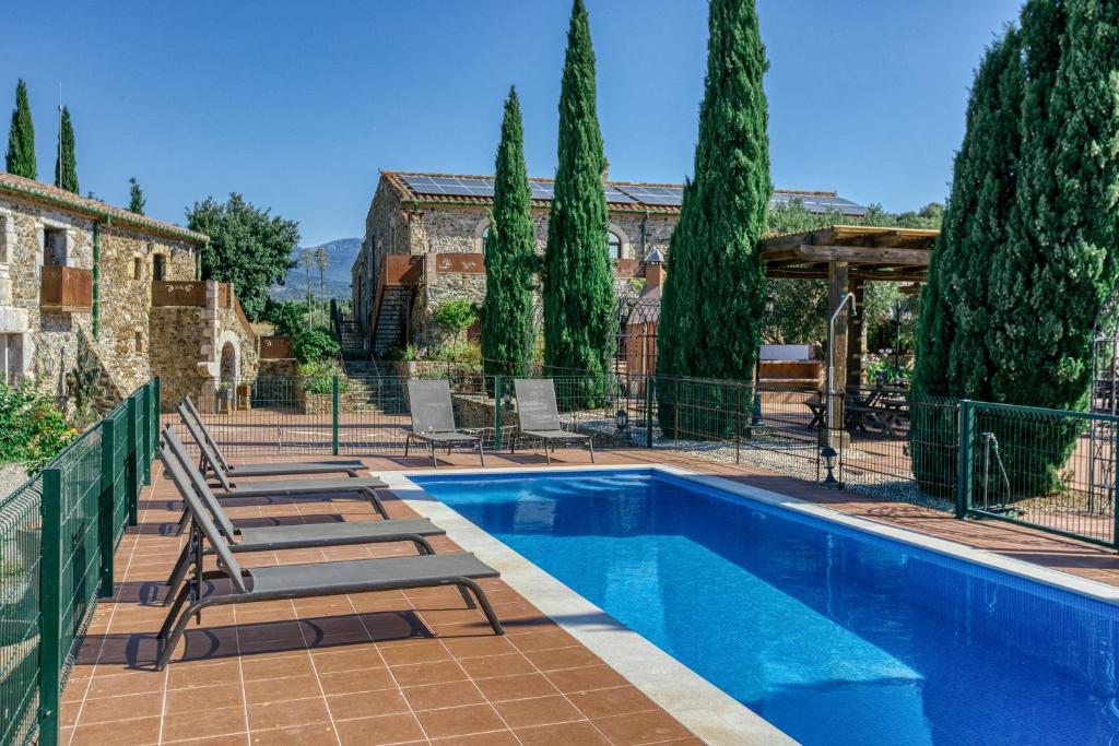 a swimming pool with lounge chairs next to a building at Mas Renart in Mollet de Perelada