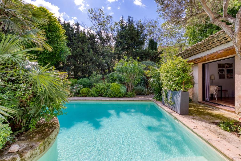 a swimming pool in the yard of a house with plants at Villa - Oasis centre charme in Montpellier