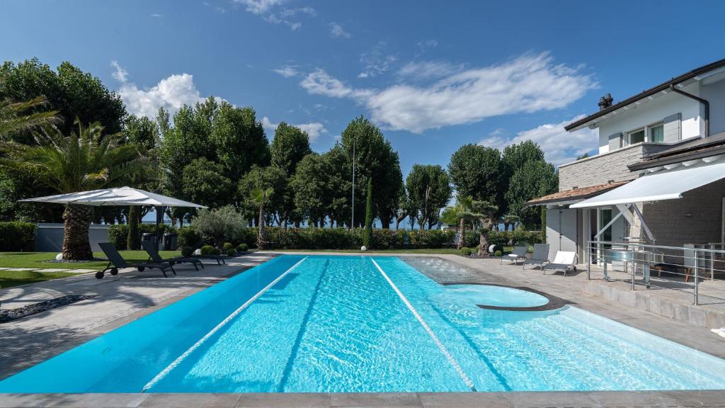 a swimming pool in the backyard of a house at Villa Sirmione Front Lake in Sirmione