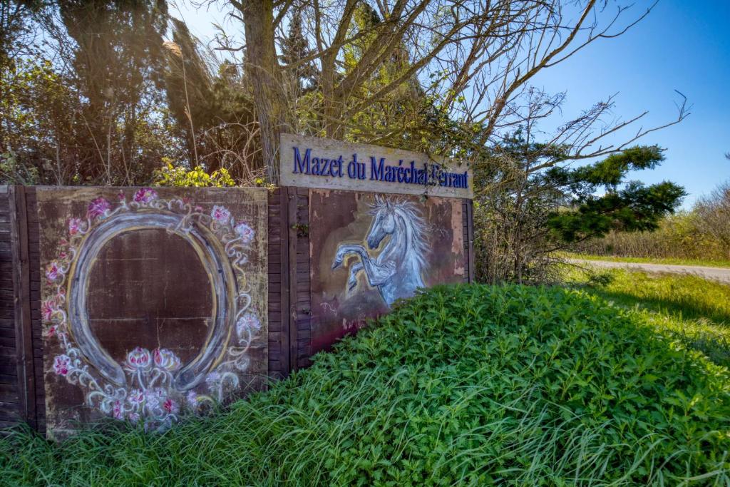 a sign on a wall with a painting on it at Le Mazet Du Maréchal Ferrant in Maguelonne-la-Sauvage