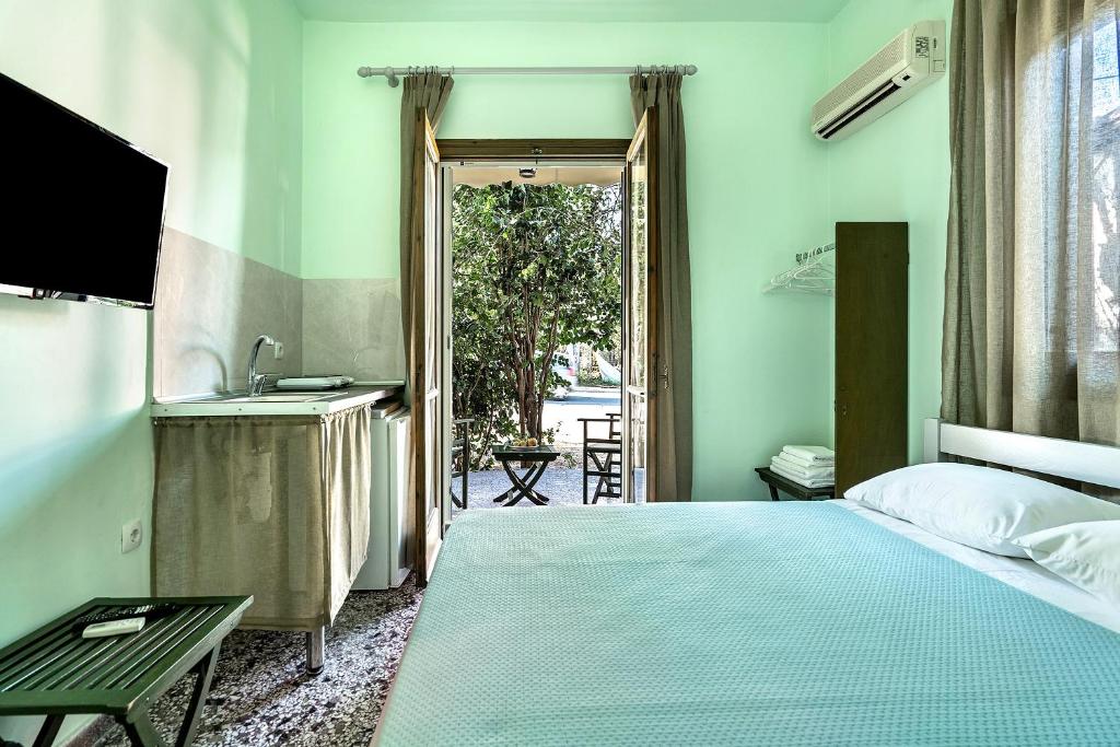 a bedroom with a bed and a sink and a television at Old Boat double studio 1 in Nikiana